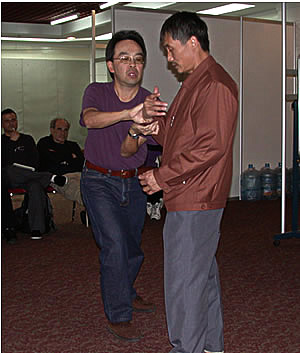 Meister Jiang Zhong Bao bei seiner abendlichen Lecture mit einem amerikanischen Schüler bei einer Tai Chi Abwehr.