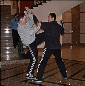 Meister Wu Ji bei einer Abwehr eines Kicks mit einem amerikanischen Studenten